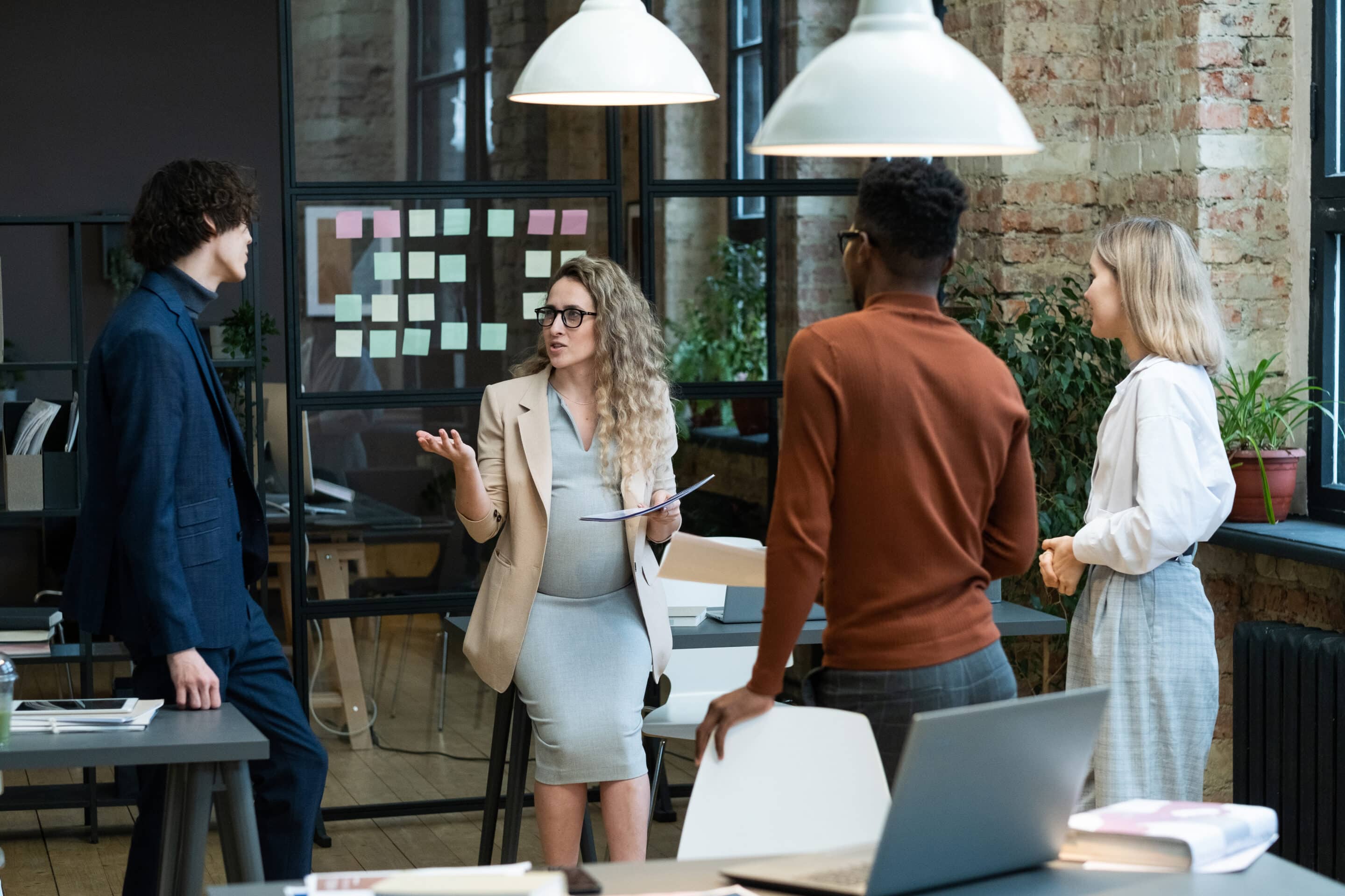 Work colleagues with a focus on a pregnant colleague talking
