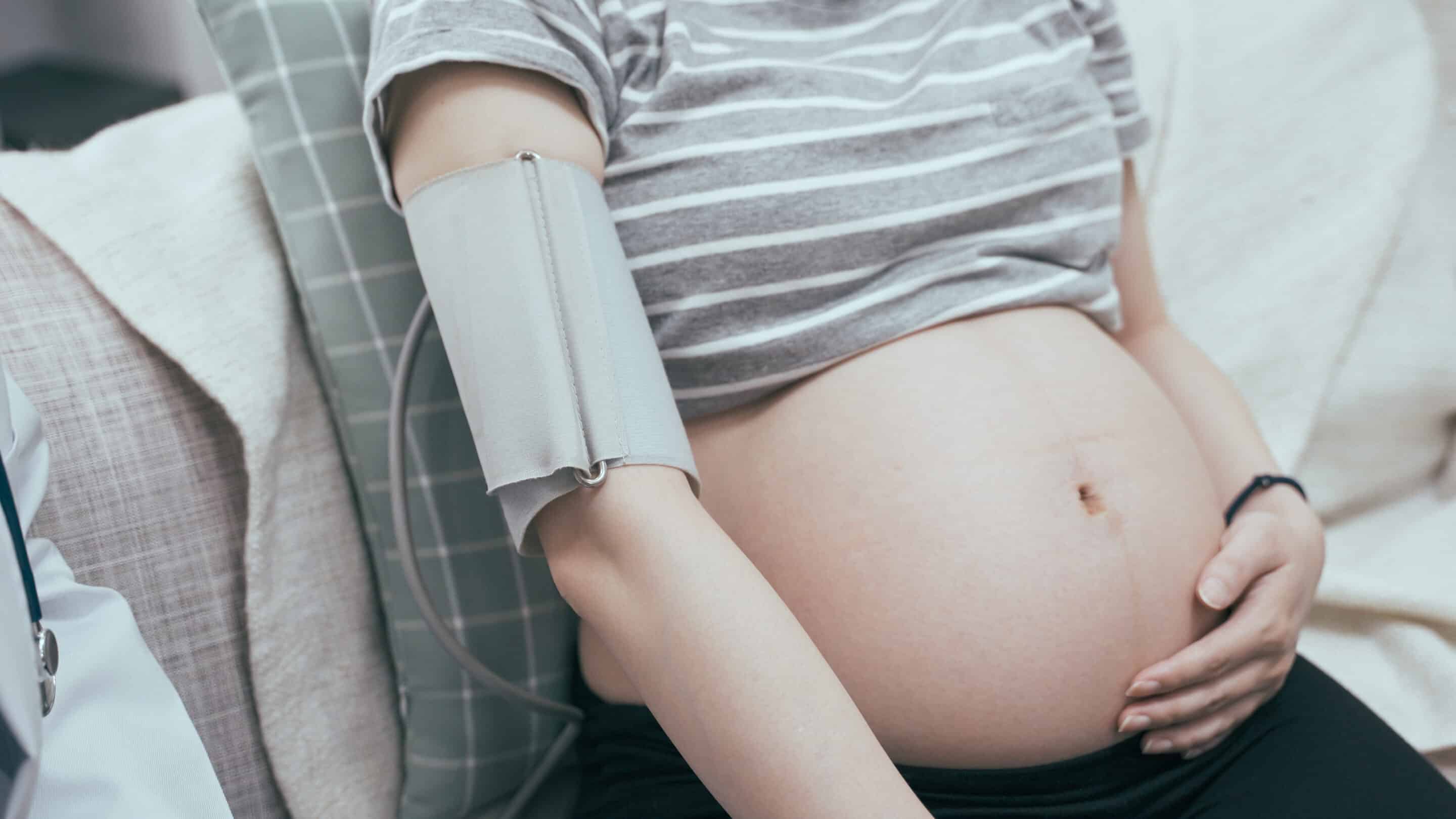 A pregnant woman siting having her blood pressure checked