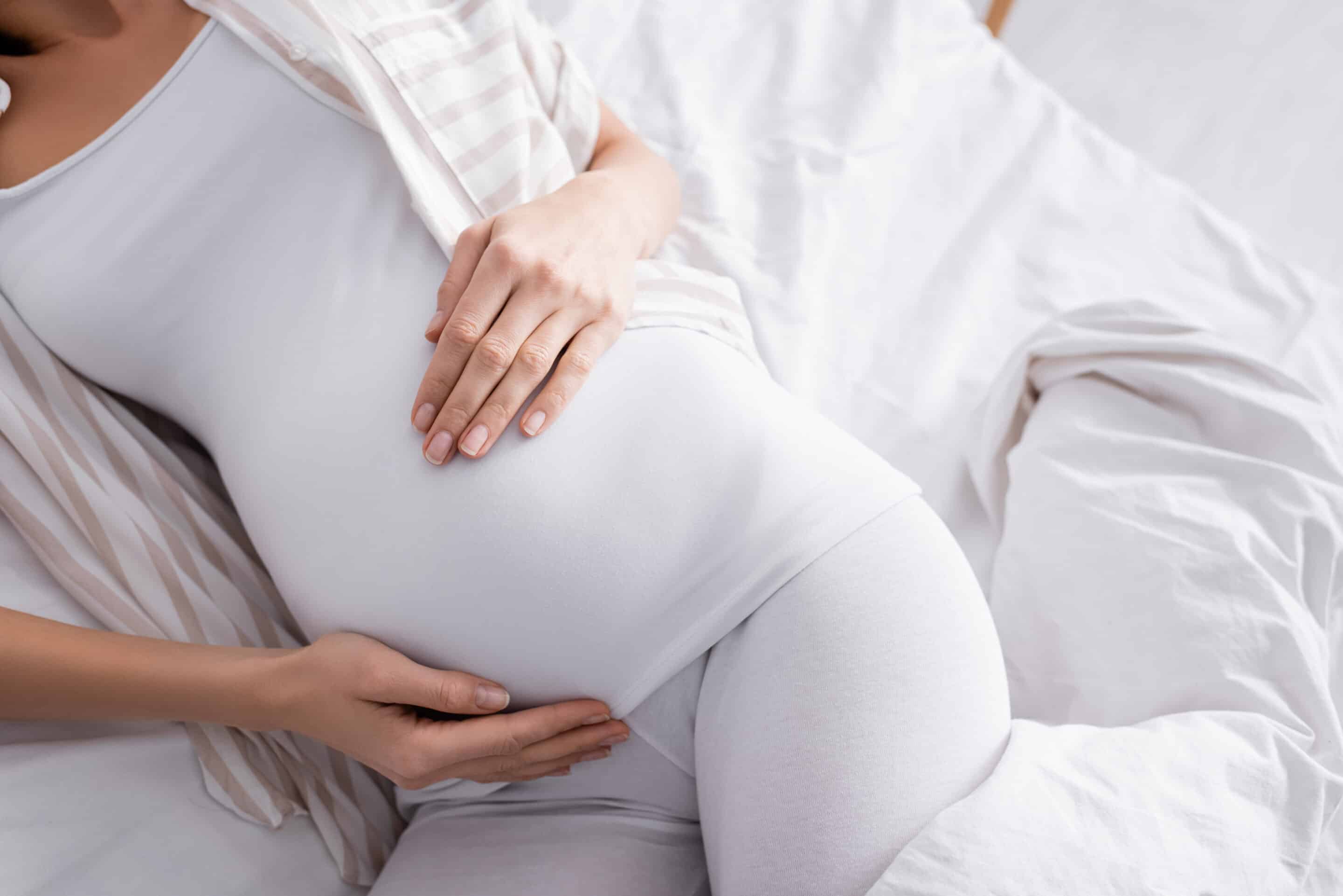 View from above of a pregnant woman resting holding her bump