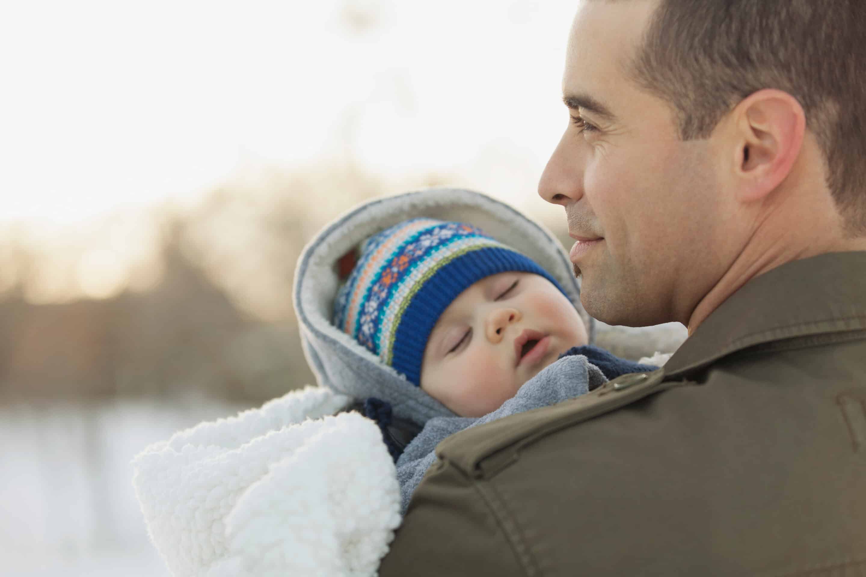 Baby's sleep in winter with dad outside
