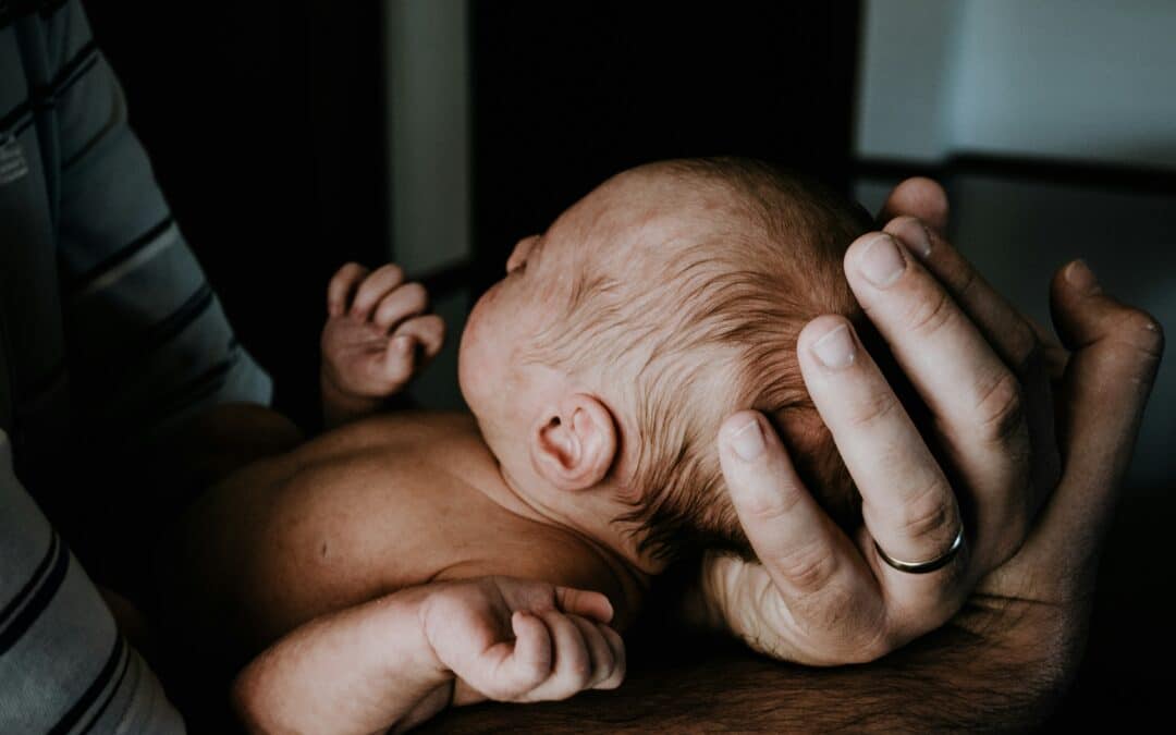 home birth or hospital birth. newborn baby in father's hands